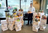Local orthodontist, Dr. Chris Rose, poses with Girl Scout cookies bound for sailors on deployment. 
